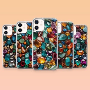 May include: Five phone cases with a gemstone design. The cases feature a variety of colorful gems in shades of blue, green, orange, purple, and brown. The gemstones are arranged in a mosaic pattern.