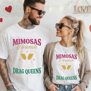 Può includere: Due persone indossano magliette bianche con la scritta "Mimosas & brunch Drag Queens" in rosa, oro e verde. Le magliette presentano una grafica di due calici di champagne. Entrambi indossano occhiali da sole.