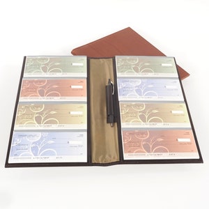 May include: An 8-book checkbook in a chocolate brown leather cover. The checkbook has eight clear plastic sleeves, each holding a check. The checkbook also includes a pen.
