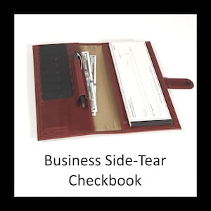 Peut inclure: Un porte-chéquier en cuir rouge foncé avec une fermeture à pression, plusieurs fentes noires pour cartes, un passant pour stylo avec un stylo noir et une doublure intérieure beige. L'étui ouvert contient des billets et un chéquier professionnel.