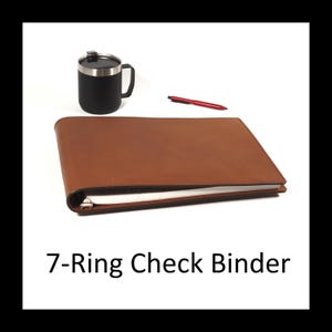 May include: A brown leather 7-ring check binder lying flat, accompanied by a black insulated mug with a lid and a red pen. The text 7-Ring Check Binder is printed below the items, which are arranged on a plain white background.