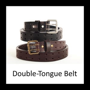 May include: Two double-tongue belts stacked on top of each other. The top belt is black with a silver buckle, and the bottom belt is brown with a gold buckle. Both belts have evenly spaced holes. The text "Double-Tongue Belt" is at the bottom.