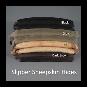 May include: A stack of slipper sheepskin hides in black, gray, tan, and dark brown. The image includes the text "Black", "Gray", "Tan", and "Dark Brown" labeling each hide. The bottom of the image reads "Slipper Sheepskin Hides".