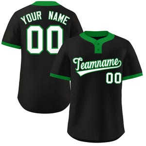 May include: Black baseball jersey with green trim and accents. The jersey features the text "Teamname" and the number "00" on the front, and "YOUR NAME" and "00" on the back. The jersey has a button-up front and short sleeves.