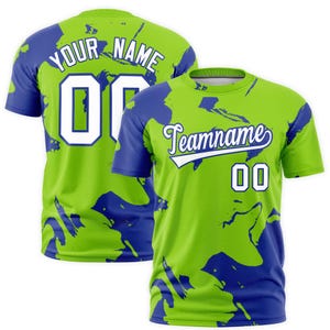 Puede incluir: Una camiseta deportiva verde y azul con el texto "Your Name" y "00" en la espalda. La parte delantera muestra "Teamname" y "00". La camiseta tiene un patrón único.