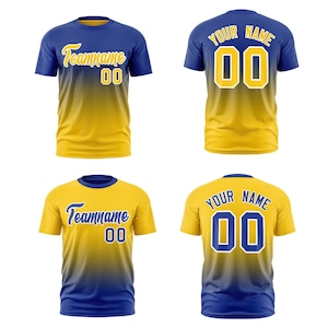 May include: Two short-sleeve crew neck t-shirts shown from front and back views. One shirt features a blue-to-yellow gradient with yellow text reading Teamname and 00. The other is yellow-to-blue with blue text reading Teamname and 00.