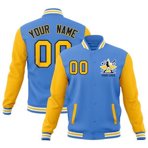 Puede incluir: Chaqueta de béisbol azul y amarilla con el texto "YOUR NAME" y el número "00" en la espalda. La parte delantera presenta el número "00", un gráfico de jugador de béisbol y el texto "YOUR LOGO".