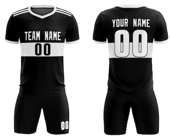May include: Black and white soccer uniform set. The jersey features a white stripe across the chest with the text "TEAM NAME" above the number "00". The shorts also have the number "00". The back of the jersey has the text "YOUR NAME" above the number "00".