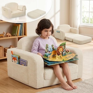 May include: A cream-colored corduroy children's armchair with a matching ottoman. The chair has a pocket on the side for books. A child is sitting in the chair reading a pop-up book with a lion on the cover.