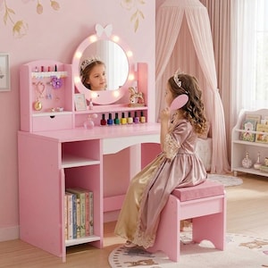 May include: A pink vanity table with a round lighted mirror, a side shelf with a small drawer, and an open storage compartment for books. The vanity includes a matching pink stool with a cushioned seat, designed for organizing cosmetics and accessories.