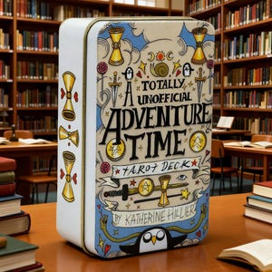 May include: A rectangular tin featuring the text "A Totally Unofficial Adventure Time Tarot Deck" with illustrations of hourglasses, swords, and stars. The tin is white with a blue border and gold accents. The product is sitting on a wooden table in a library.