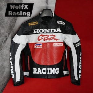 May include: A black, white, and red leather racing jacket with "HONDA CBR" and "RACING" text. The jacket has a stand-up collar, white stripes on the sleeves, and sponsor logos. The jacket is suspended against a red backdrop.