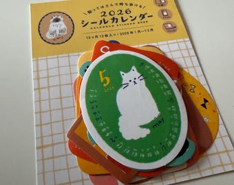 May include: A set of cat-themed stickers and a calendar. The stickers feature a white cat illustration on a green background, with the month of May and the number 5. The calendar is labeled "2026" and includes Japanese text.