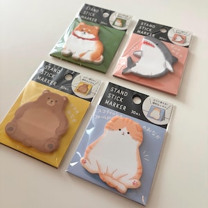 May include: Four packs of Stand Stick Markers, each with a different animal design: a Shiba Inu, a shark, a bear, and a Scottish Fold cat. Each pack contains 30 markers and features Japanese text.