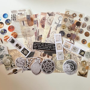 May include: A selection of celestial-themed stickers and ephemera. The assortment includes planets, moons, gears, and vintage-style illustrations. Some pieces feature text like "Moon," "Secrets," and "Soulmate." The color palette is primarily beige, brown, and white.