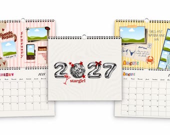 Peut inclure: Un calendrier mural 2027 avec une couverture centrale affichant des chiffres argentés en forme de ballons, une boule à facettes et le texte 'stargirl'. Deux pages de calendrier ouvertes sont visibles, montrant février et août avec des motifs.