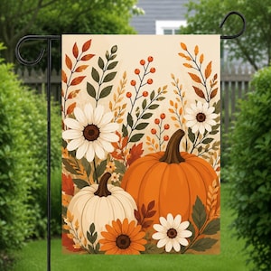 May include: A rectangular garden flag featuring a seasonal autumn illustration with a large orange pumpkin and a smaller white pumpkin. The design includes white daisies, orange sunflowers, and various fall-colored leaves and berry sprigs.