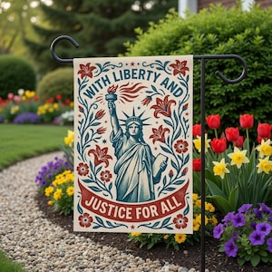 May include: A garden flag featuring the Statue of Liberty holding a torch, surrounded by floral elements. The flag reads "WITH LIBERTY AND JUSTICE FOR ALL" in a vintage style. The flag is displayed in a garden setting.