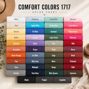 May include: A Comfort Colors 1717 color chart displaying a grid of folded fabric swatches in various shades. Each swatch is labeled with its specific color name, including White, Ivory, Banana, Butter, Mustard, Terracotta, Burnt Orange, Yam, Grey, Granite, Black, Pepper, Graphite, and many others.
