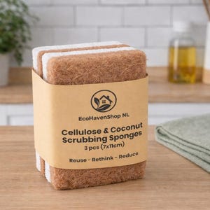 May include: A pack of three rectangular scrubbing sponges featuring a brown coconut fiber scouring side and a white cellulose sponge side. The sponges are wrapped in a tan paper band labeled EcoHavenShop NL Cellulose & Coconut Scrubbing Sponges 3 pcs (7x11cm) Reuse - Rethink - Reduce.