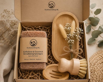 May include: A gift box containing cellulose and coconut scrubbing sponges, a wooden dish, a wooden brush, and a bamboo tray. The box includes dried flowers and is filled with brown crinkle paper. The sponges are 2.75 x 4.33 inches.