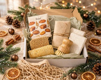 May include: A cardboard gift box containing a white cloth bag with bread illustrations, two textured loofah sponges, a wooden dish brush with light bristles, and two rectangular beige cleaning cloths tied with twine, all nestled in light green tissue paper.