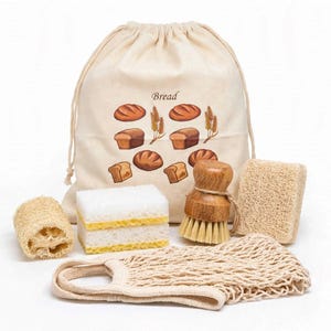 May include: A beige drawstring bag with the word Bread printed above illustrations of various loaves and wheat stalks, accompanied by a white and yellow sponge, a round wooden scrub brush, two rectangular loofah sponges, and a beige mesh bag.