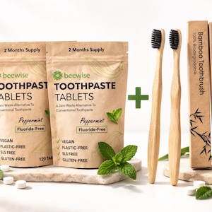 Op de afbeelding: Een milieuvriendelijke tandverzorgingsset met twee zakjes tandpastatabletten, twee bamboe tandenborstels en twee dozen bamboe tandenborstels. De tabletten zijn pepermunt, fluoridevrij, veganistisch, plasticvrij, SLS-vrij en glutenvrij.