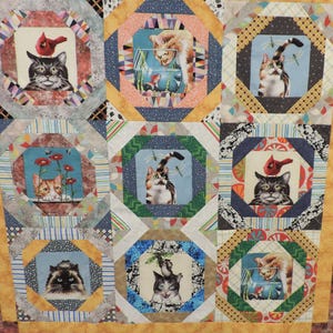 May include: A handmade quilt featuring nine squares with cat-themed images. Each square has a different cat portrait, some with birds or dragonflies. The quilt has a colorful patchwork design with various patterned fabrics and a yellow border.