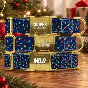 May include: Three navy blue pet collars featuring a colorful Christmas light bulb pattern and gold-tone metal buckles. Each buckle is engraved with a name, COOPER, STELLA, or MILO, and the phone number 123-456-7890 in a clean white font.