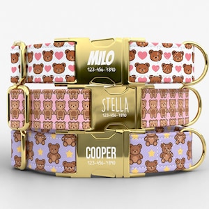 May include: Three personalized dog collars with gold-colored buckles. The top collar is white with brown teddy bears and pink hearts. The middle collar is pink with brown teddy bears. The bottom collar is purple with brown teddy bears and yellow stars. Each buckle has a name and phone number.