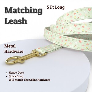 Puede incluir: Una correa para perros de 152 cm de largo con un estampado floral en rosa, amarillo y blanco sobre un fondo verde claro. La correa tiene herrajes met&aacute;licos y el texto "Matching Leash" y "Metal Hardware". Incluye construcci&oacute;n resistente y cierre r&aacute;pido.