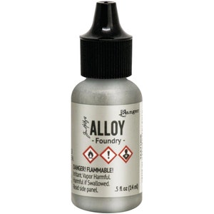 May include: A silver-colored bottle of Ranger Alloy Foundry ink with a black cap. The label includes the word "ALLOY", hazard symbols, and the text "DANGER! FLAMMABLE!" The bottle contains 0.5 fl oz (14 ml) of ink.