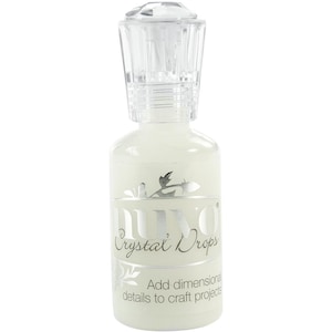 May include: A clear bottle of Nuvo Crystal Drops adhesive with a silver label that says "Nuvo Crystal Drops" and "Add dimensional details to craft projects".
