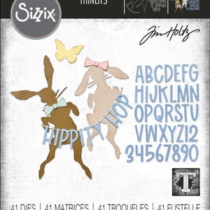 May include: Sizzix Thinlits die set featuring bunny silhouettes, letters, numbers, and a butterfly. The bunnies have bows and a banner that says "Hippity Hop". The letters and numbers are in a light blue color.