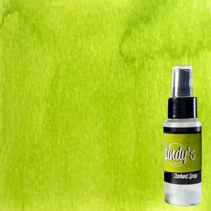 May include: A bottle of Lindy's Starburst Sprays with a black and white label, set against a bright green watercolor background. The spray bottle has a clear cap and a black collar. The background has a textured, watercolor effect.