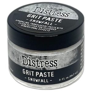 May include: A clear glass jar of Ranger Distress Grit Paste in the color "Snowfall." The jar has a black lid and a black label with white text that reads "Distress Grit Paste - Snowfall." The paste is a sparkling, translucent paste with clear glitter for textured dimensional effects. The jar contains 3 fl oz (88.7 ml).