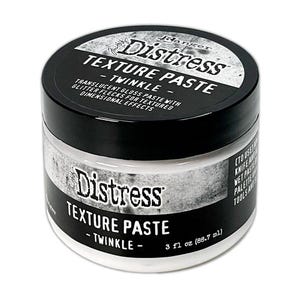 May include: A jar of Distress Texture Paste in the Twinkle variant. The black lid features the product name and brand, with the jar's label also displaying the product name. The jar contains a translucent gloss paste with glitter flecks, 3 fl oz (88.7 ml).