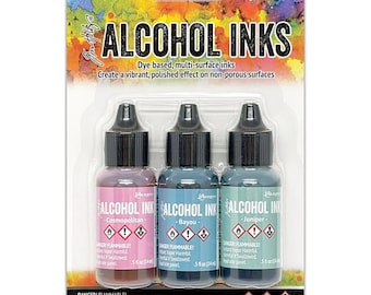 May include: A package of three alcohol inks in Cosmopolitan, Bayou, and Juniper colors. The bottles are labeled "Alcohol Ink" and "Danger! Flammable!" The package includes 3 bottles of 0.5 fl oz (14 ml) each.