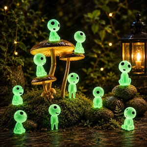 Puede incluir: Una colección de pequeñas figuras de color verde brillante con cabezas grandes y redondas y ojos negros, colocadas sobre y alrededor de sombreros de hongos marrones y rocas cubiertas de musgo. Las figuras tienen cuerpos lisos y redondeados.
