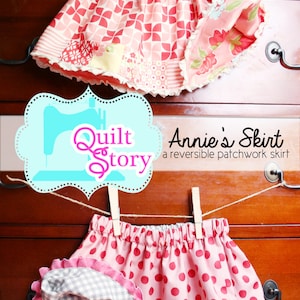 May include: Two reversible patchwork skirts hanging on a wooden dresser. The top skirt is pink with a geometric pattern and floral accents. The bottom skirt is pink with white polka dots and a checkered pattern on the reverse side. The text "Quilt Story" and "Annie's Skirt" is visible on the image. The number "#132" is also visible.