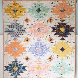 Puede incluir: Una colcha colorida con un patr&oacute;n geom&eacute;trico. La colcha est&aacute; hecha de varios tonos de naranja, amarillo, azul, verde y rosa. La colcha est&aacute; hecha de una serie de cuadrados con un patr&oacute;n de diamante en el centro.