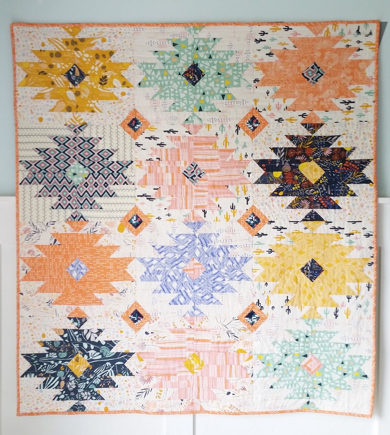 Puede incluir: Una colcha colorida con un patr&oacute;n geom&eacute;trico. La colcha est&aacute; hecha de varios tonos de naranja, amarillo, azul, verde y rosa. La colcha est&aacute; hecha de una serie de cuadrados con un patr&oacute;n de diamante en el centro.