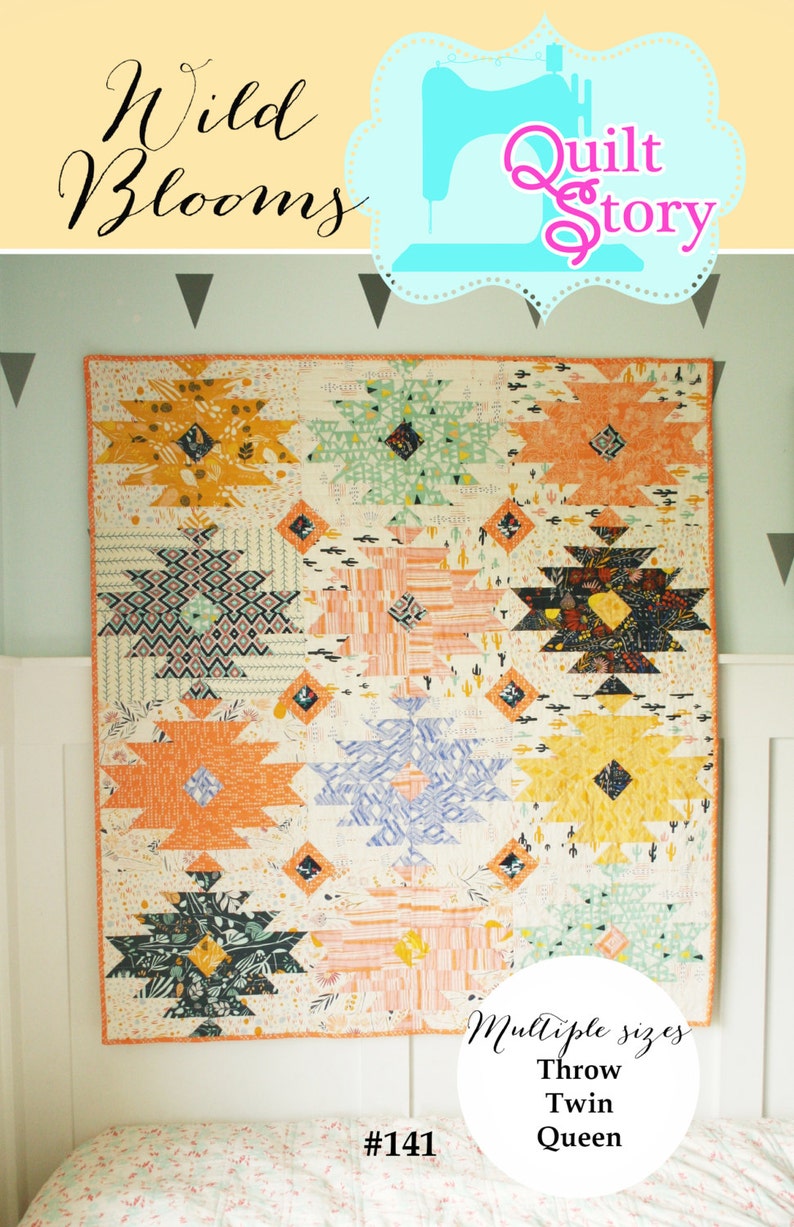 Puede incluir: Una colcha colorida con un patr&oacute;n geom&eacute;trico en tonos naranja, amarillo, verde, azul y rosa. La colcha est&aacute; colgada en una pared y tiene el texto "Wild Blooms" y "Quilt Story" en la parte superior. La colcha est&aacute; disponible en tama&ntilde;os de tiro, doble y queen. El n&uacute;mero de patr&oacute;n de la colcha es #141.