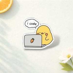 May include: A die-cut sticker featuring a yellow, round character sitting at a grey laptop with a small orange carrot icon on the lid. A white speech bubble above the character contains the black text "i code" in a simple, rounded font.