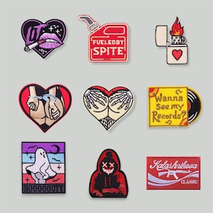 Puede incluir: Una colección de nueve parches bordados con varios diseños. Los parches incluyen un corazón con labios y un cigarrillo, una lata de gasolina roja con el texto "Fueled by Spite", y un encendedor con un corazón.
