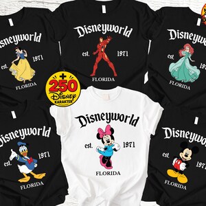 Op de afbeelding: Collectie zwarte en witte t-shirts met Disney-personages en de tekst "Disneyworld est. 1971 Florida." Personages zijn onder meer Sneeuwwitje, Iron Man, Ariel, Donald Duck, Minnie Mouse en Mickey Mouse.