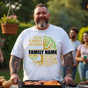 K&ouml;nnte beinhalten: Ein wei&szlig;es T-Shirt mit einem Familienfeier-Design. Das Shirt zeigt den Text "2026 FAMILY REUNION" und "FAMILY NAME" mit einer Baumgrafik. Die Person l&auml;chelt und grillt im Freien.