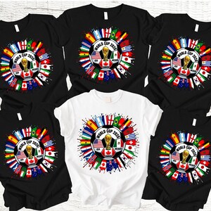 May include: A collection of black and white t-shirts featuring a soccer ball design with the text "World Cup 2026". The design includes flags of various countries and a gold trophy.