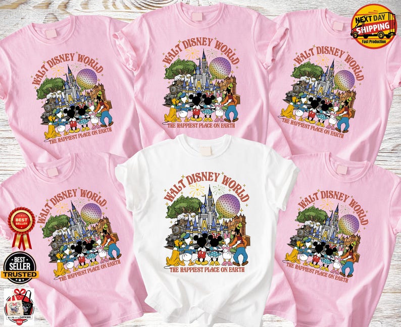 Może przedstawiać: R&oacute;żowe i białe koszulki z kolorowym nadrukiem graficznym z napisem "Walt Disney World" i "The Happiest Place on Earth". Projekt zawiera postacie z kresk&oacute;wek i zamek. Koszulki są z kr&oacute;tkim rękawem.
